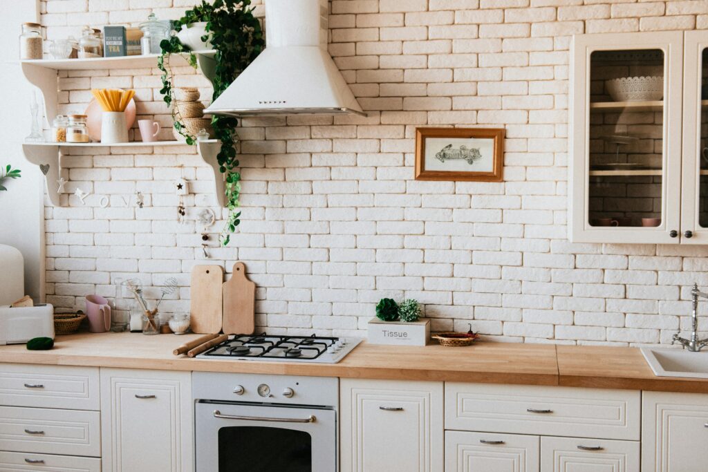 pexels-photo-2062426-2062426 Stylish kitchen interior with modern appliances, wooden counters, and greenery accents.